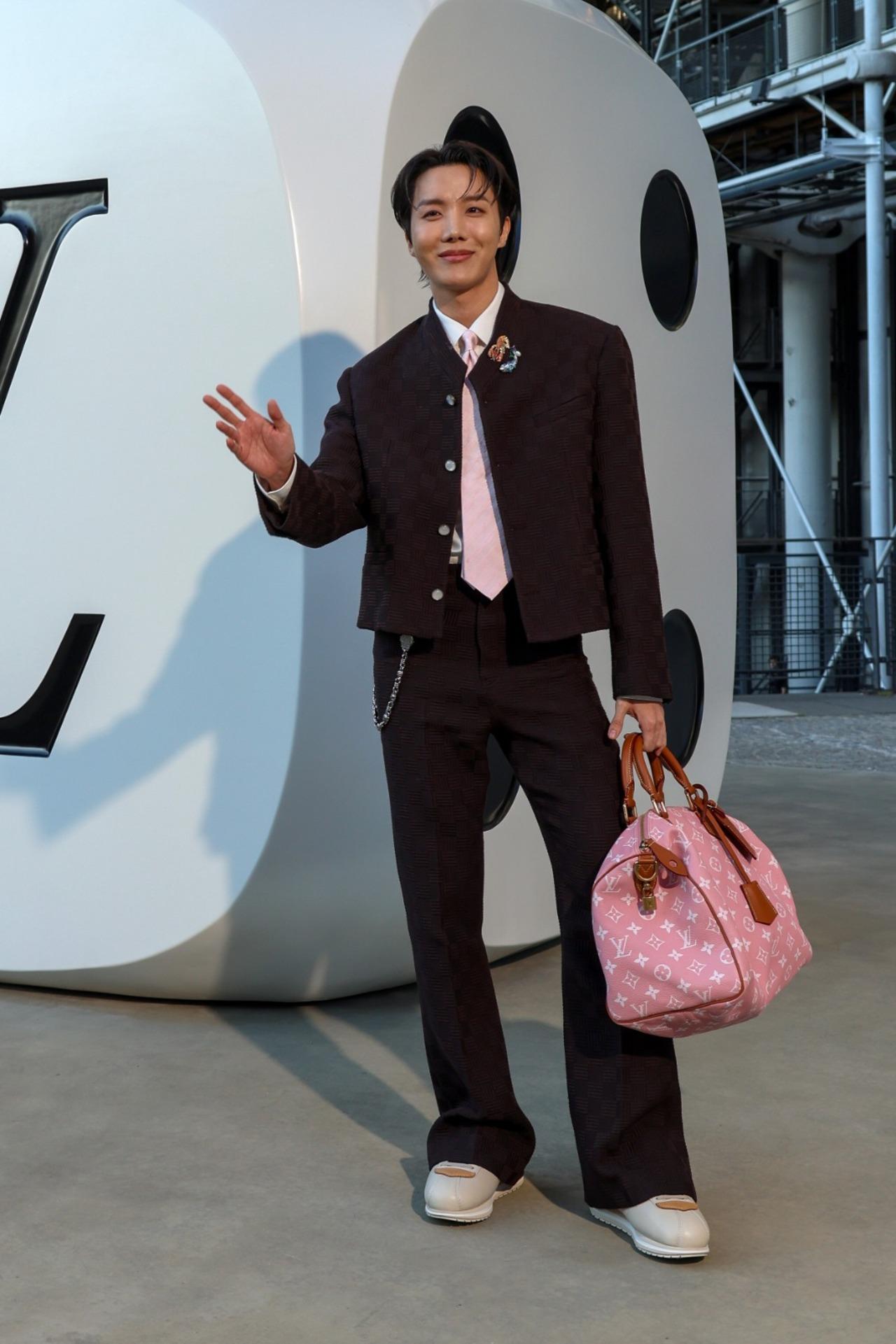 J-Hope
To match the tie, he carried a pink Louis Vuitton duffle bag. The pink stood out strikingly amid all the blues, blacks, and beiges