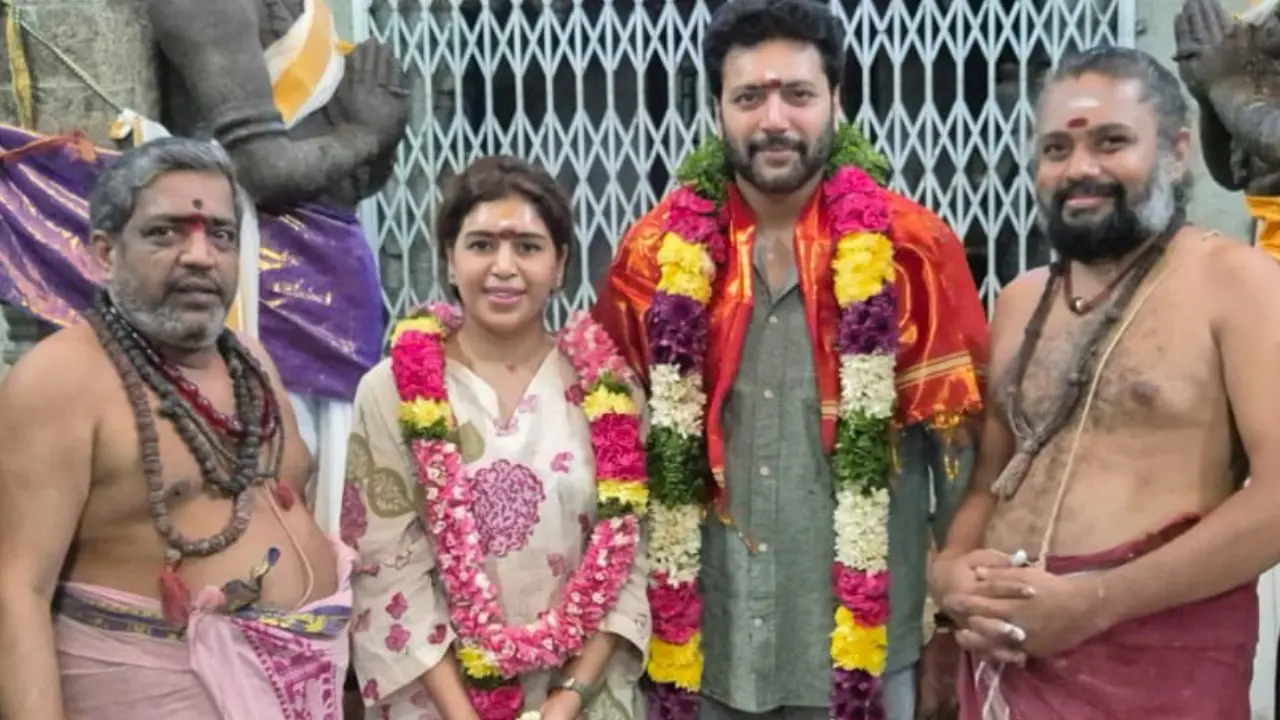 Ravi Mohan and Keneshaa Francis pose with flower garlands at temple