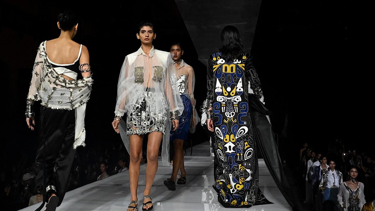Exuding power and poise, the models walked the ramp donning black, white and other silhouettes, with shades of silver elevating the essence of the look. (Pic: AFP)