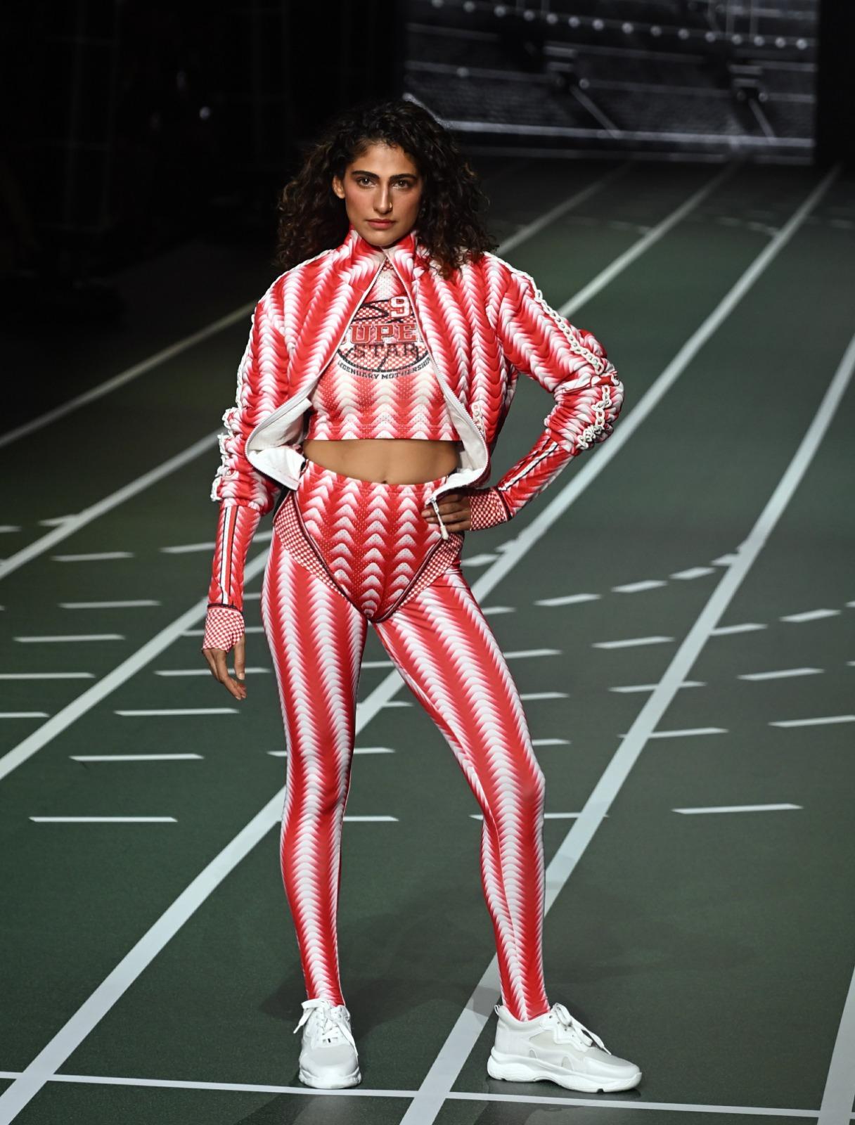 In this look, the actress wore red and white striped athleisure. She donned body-hugging pants paired with a cropped sports top and a jacket.