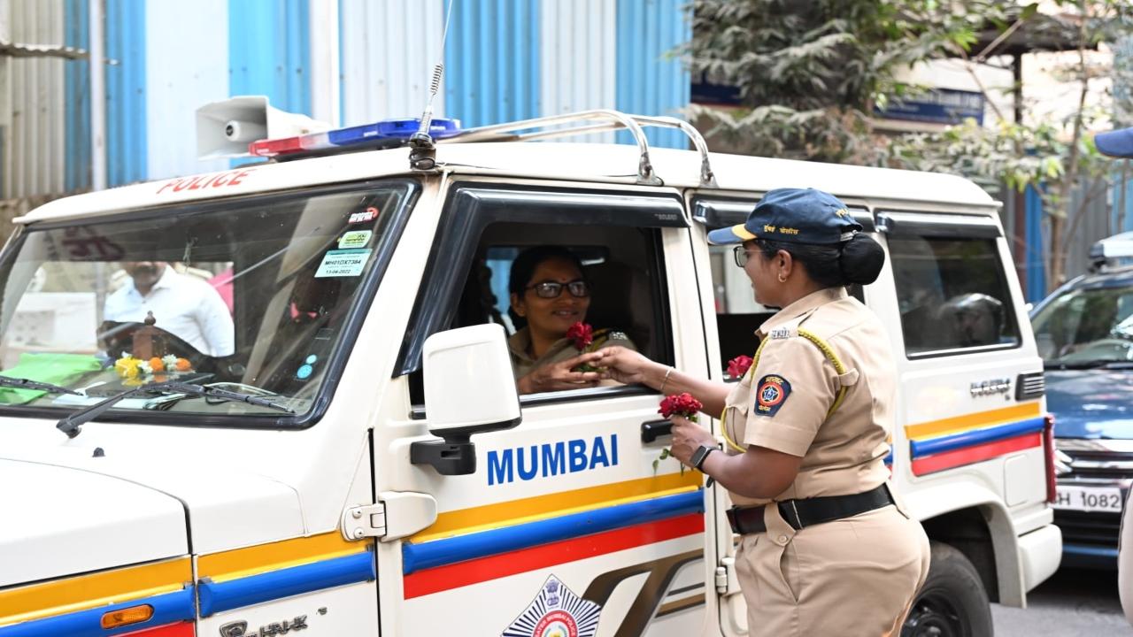 A woman personnel distributes a rose to her colleague