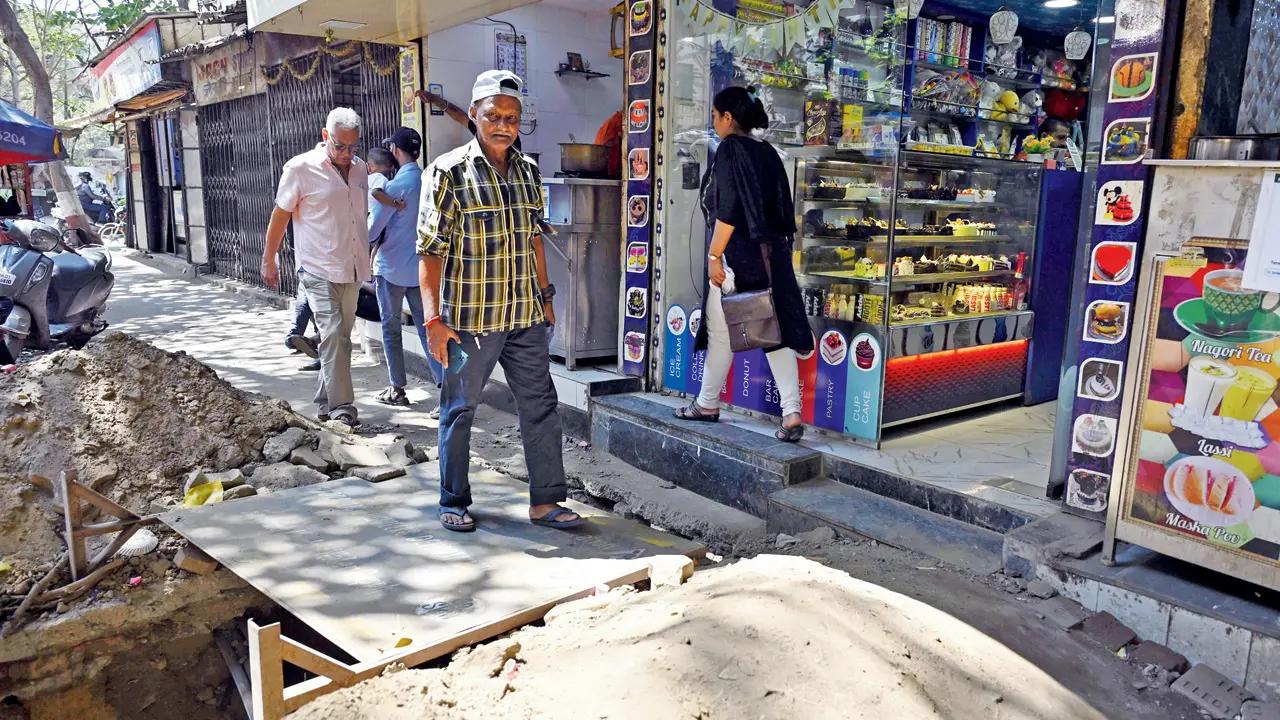 An elderly man gingerly navigates a steel board placed over a deep ditch at Mia Mohd Chhotani Road, Mahim West. Pic/Ashish Raje