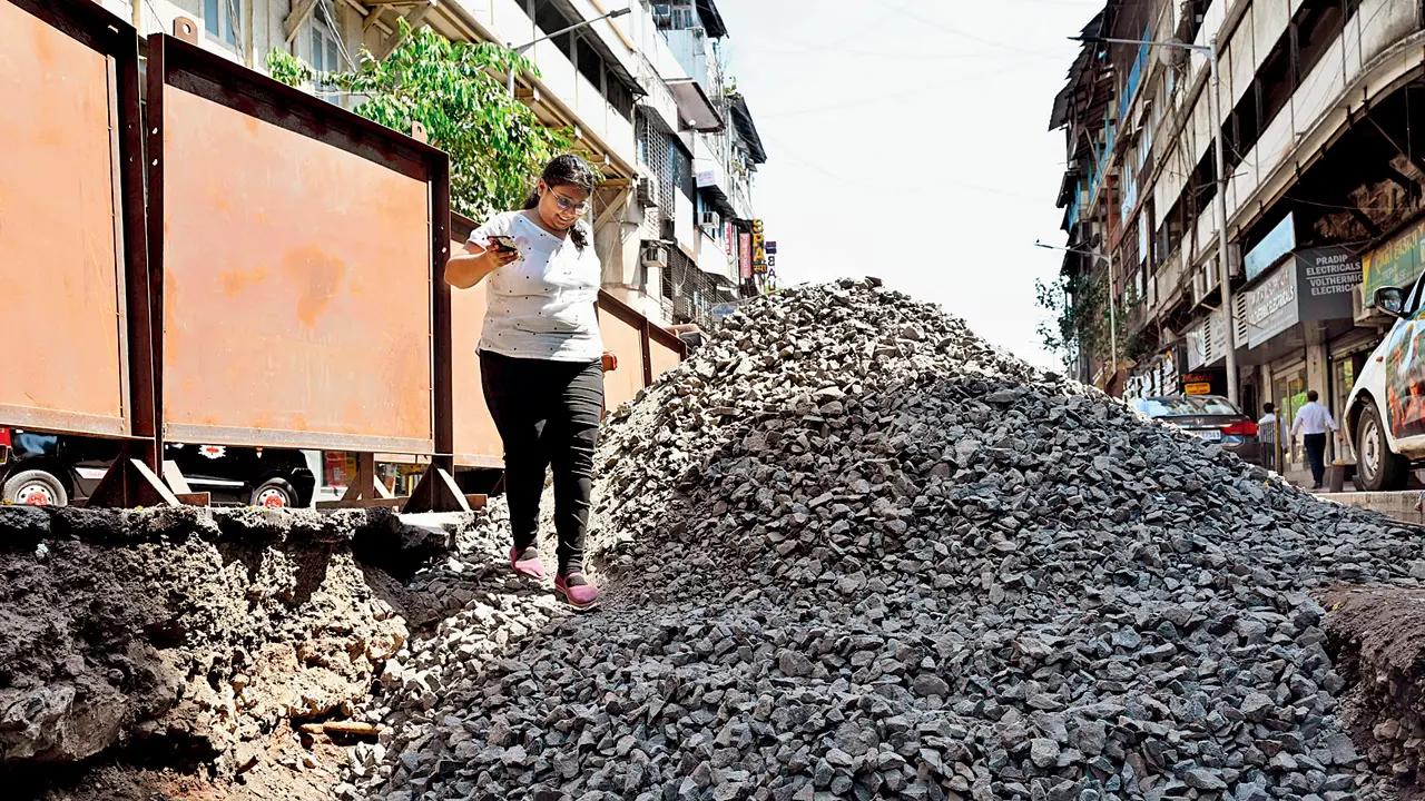 A woman navigates a scary mound of rubble to get to the other side at Marine Lines. Pic/Anurag Ahire
