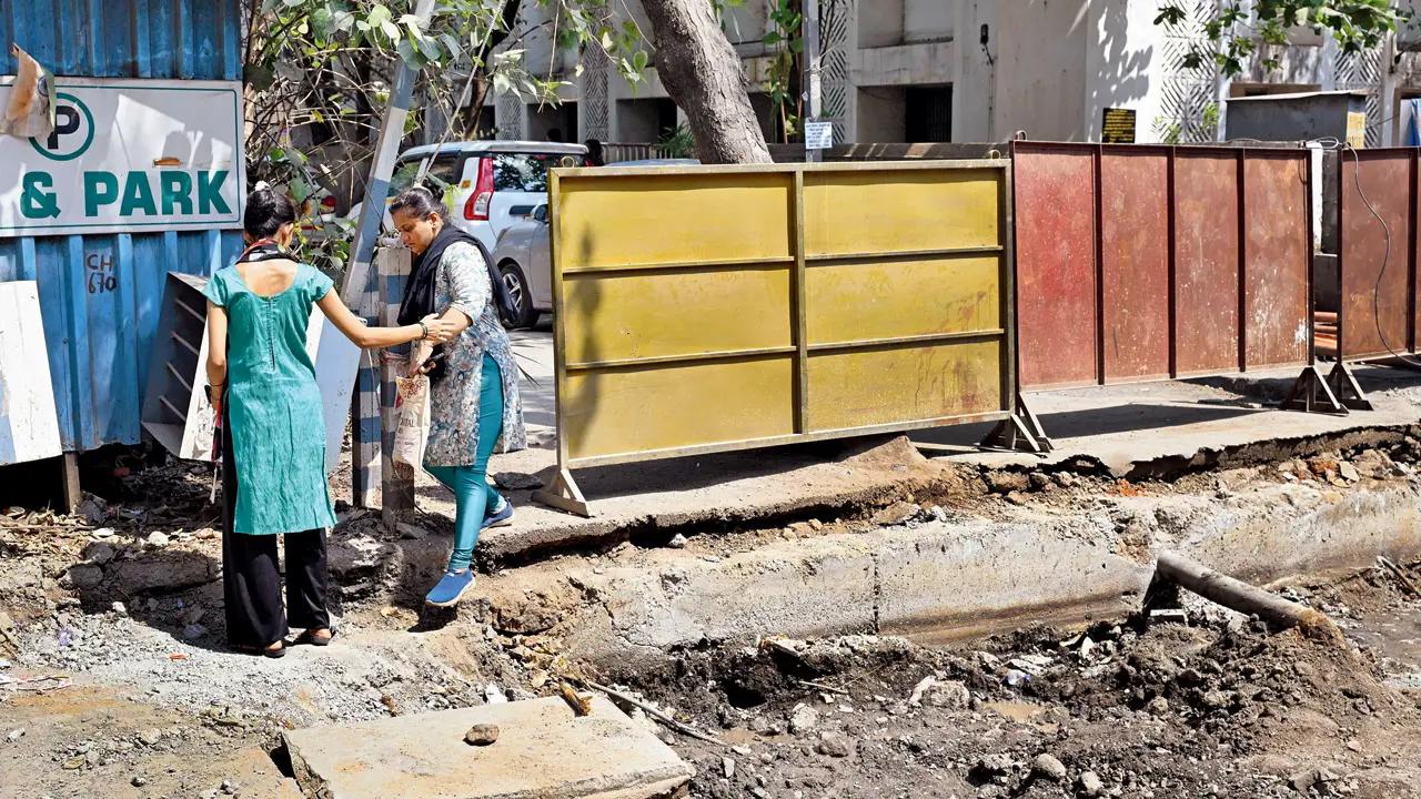 Two women try to make their way through a dangerous patch of road at Bhandup. Pic/Anurag Ahire