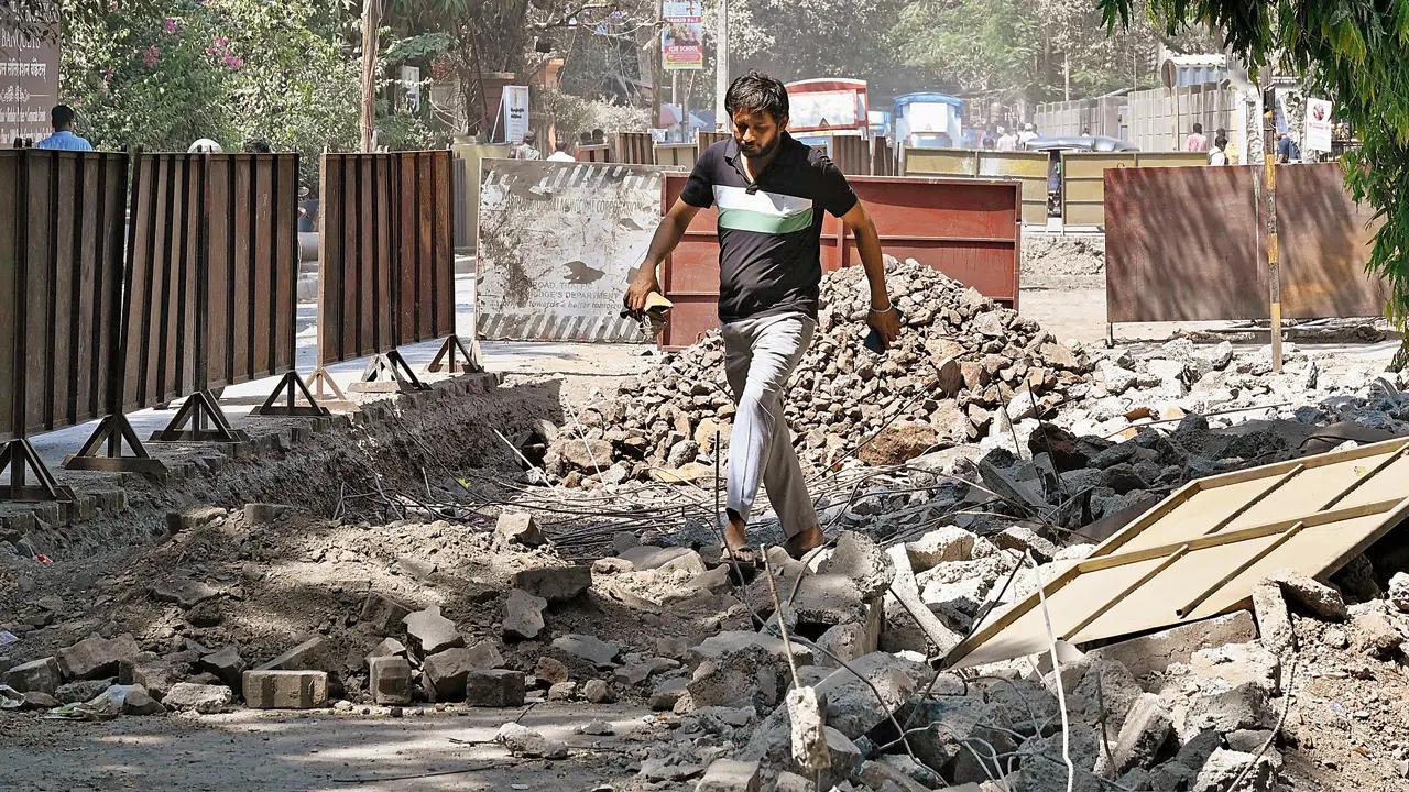 A man gingerly makes his way through debris and iron rods from a dug up road in Bhandup. Pic/Anurag Ahire