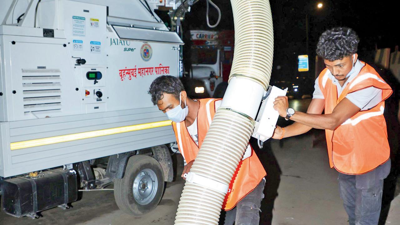 BMC workers sanitise a section of the Western Express Highway in Andheri East