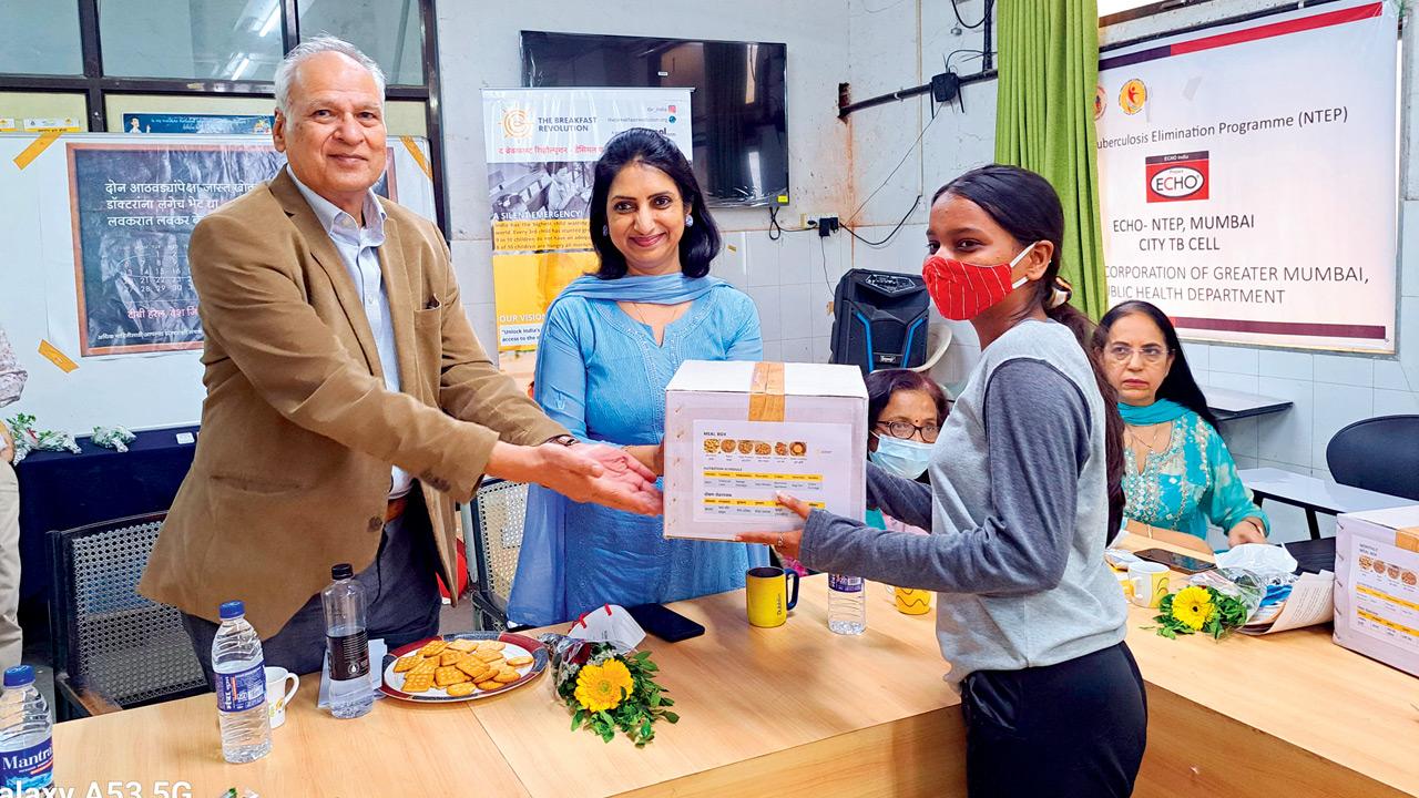 Dr Varsha Puri (centre), deputy executive health officer and city TB officer, hands out a food basket