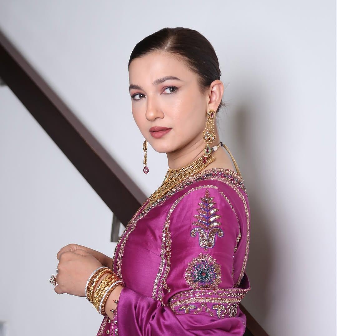 To elevate her already stunning look, Gauahar tied her hair in a chic bun and applied minimal makeup. The gold jewellery with red and green stones established a perfect contrast in her appearance