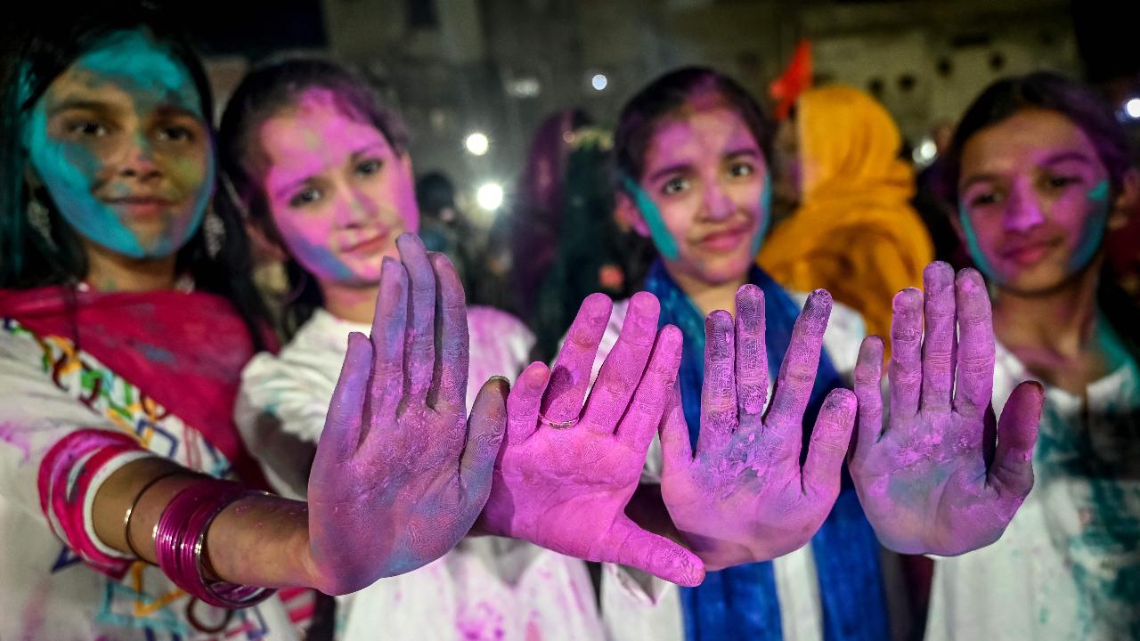 Girls show hands smeared with coloured powder during the celebration of Holi, the Hindu spring festival of colours, in Karachi