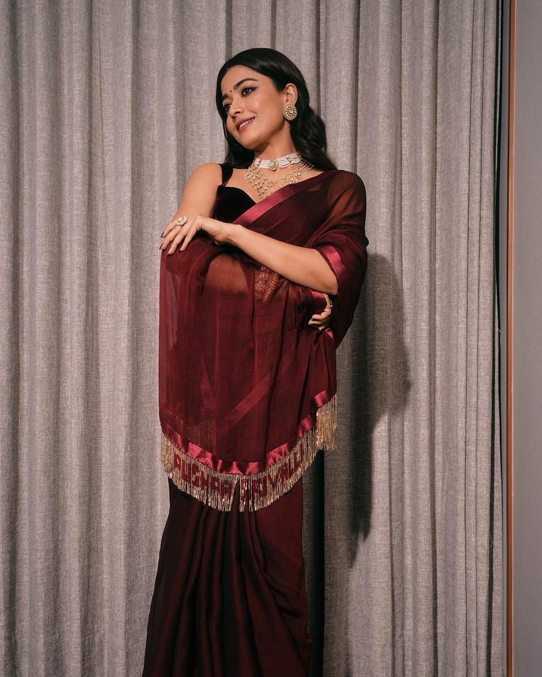 Rashmika looked breathtakingly stunning in a deep-maroon sheer saree paired with a luxurious velvet sleeveless blouse