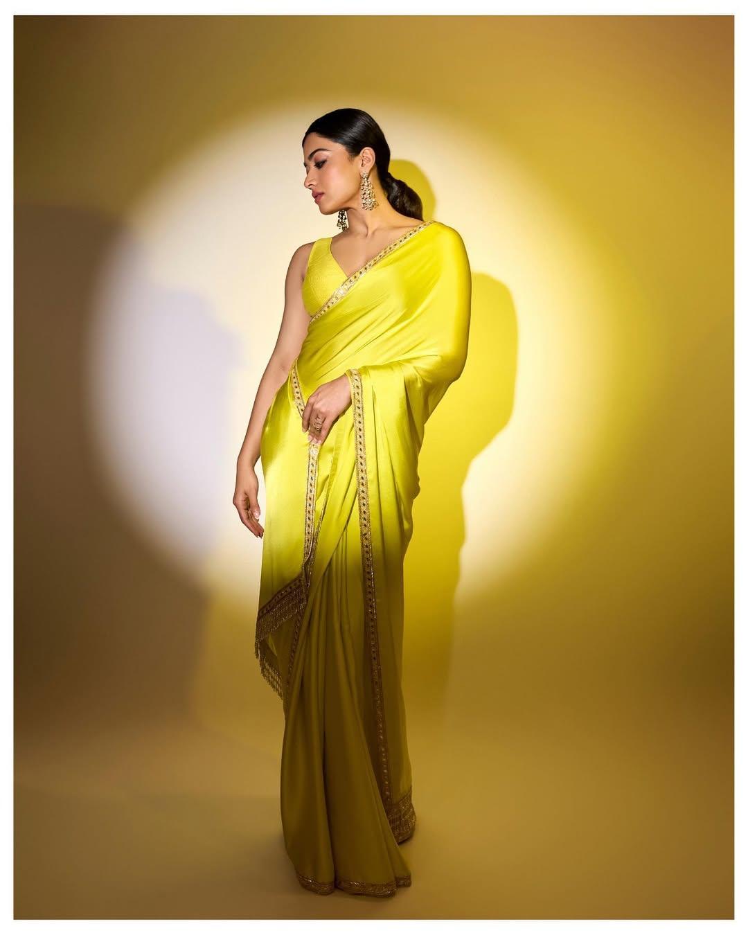 Rashmika sparkled in a vibrant satin yellow saree with golden borders, making a bold style statement