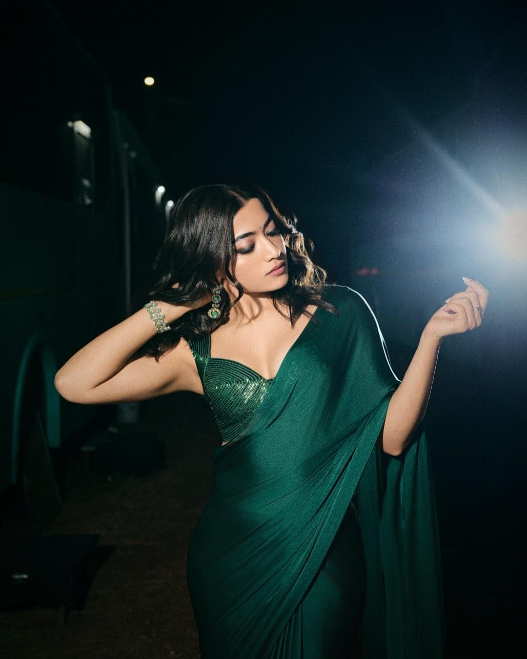 The plunging sweetheart neckline and emerald-encrusted gold dangler earrings added a touch of glamour to her festive look
