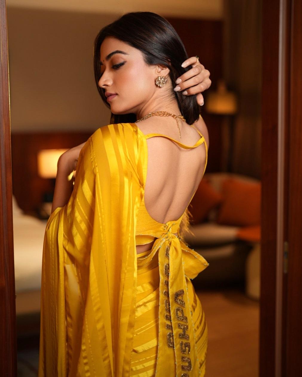 She styled it with a sleeveless scooped-neck blouse and a statement neckpiece, creating an effortlessly festive look