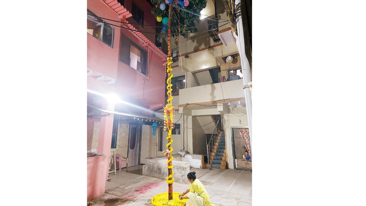 A woman arranges a flower rangoli to decorate the neighbourhood