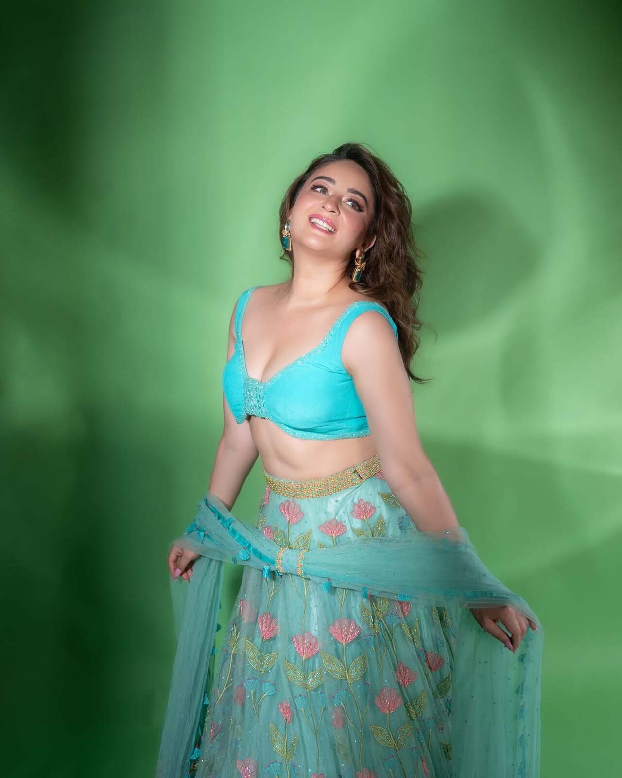 In this look, the actress wore a stunning floral-embroidered blue lehenga with a matching strappy blouse. With her hair left open, Mahhi stole hearts in her glossy makeup