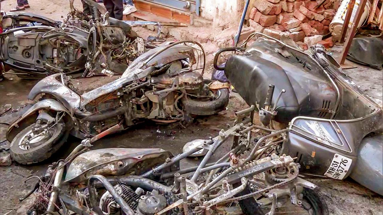 Charred remains of a vehicle after the clash in Hansapuri area in Nagpur, on Tuesday
