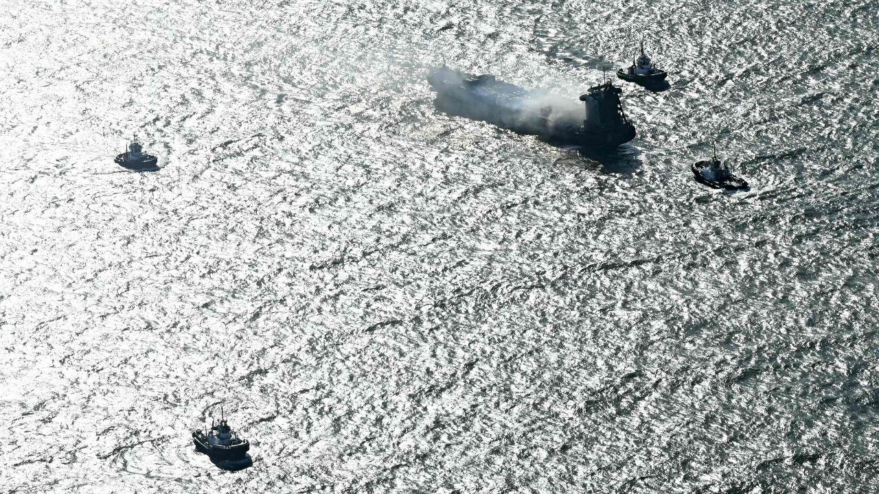 Four tugboats seen around the cargo ship in the North Sea 