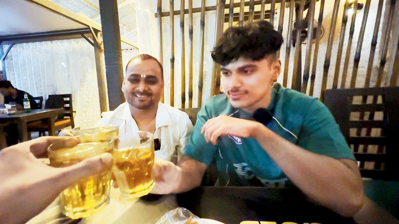 Misra (right) shares drinks with autorickshaw drivers at a bar