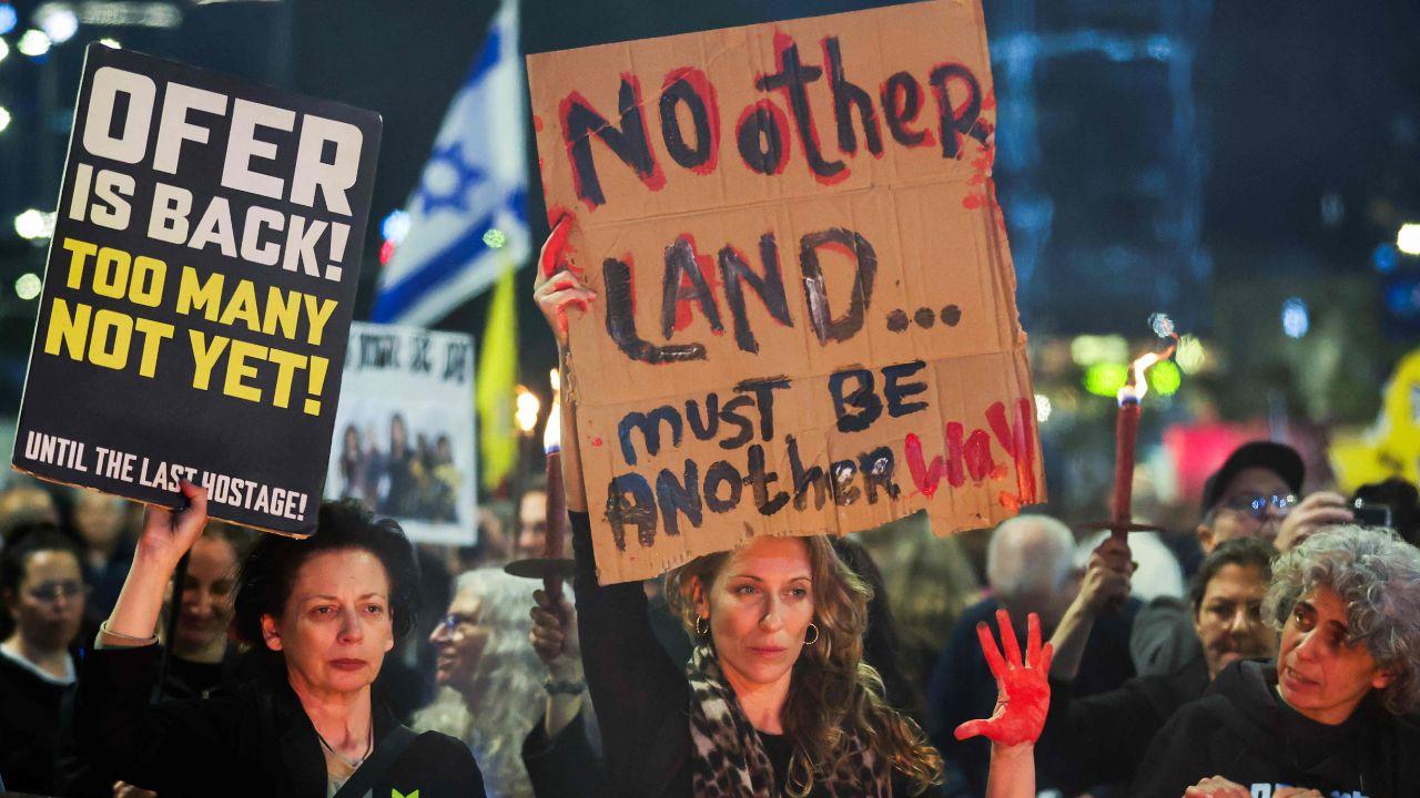People hold placards as they demand the Palestinian Militants to release all the people from Israel that are captured in Gaza    