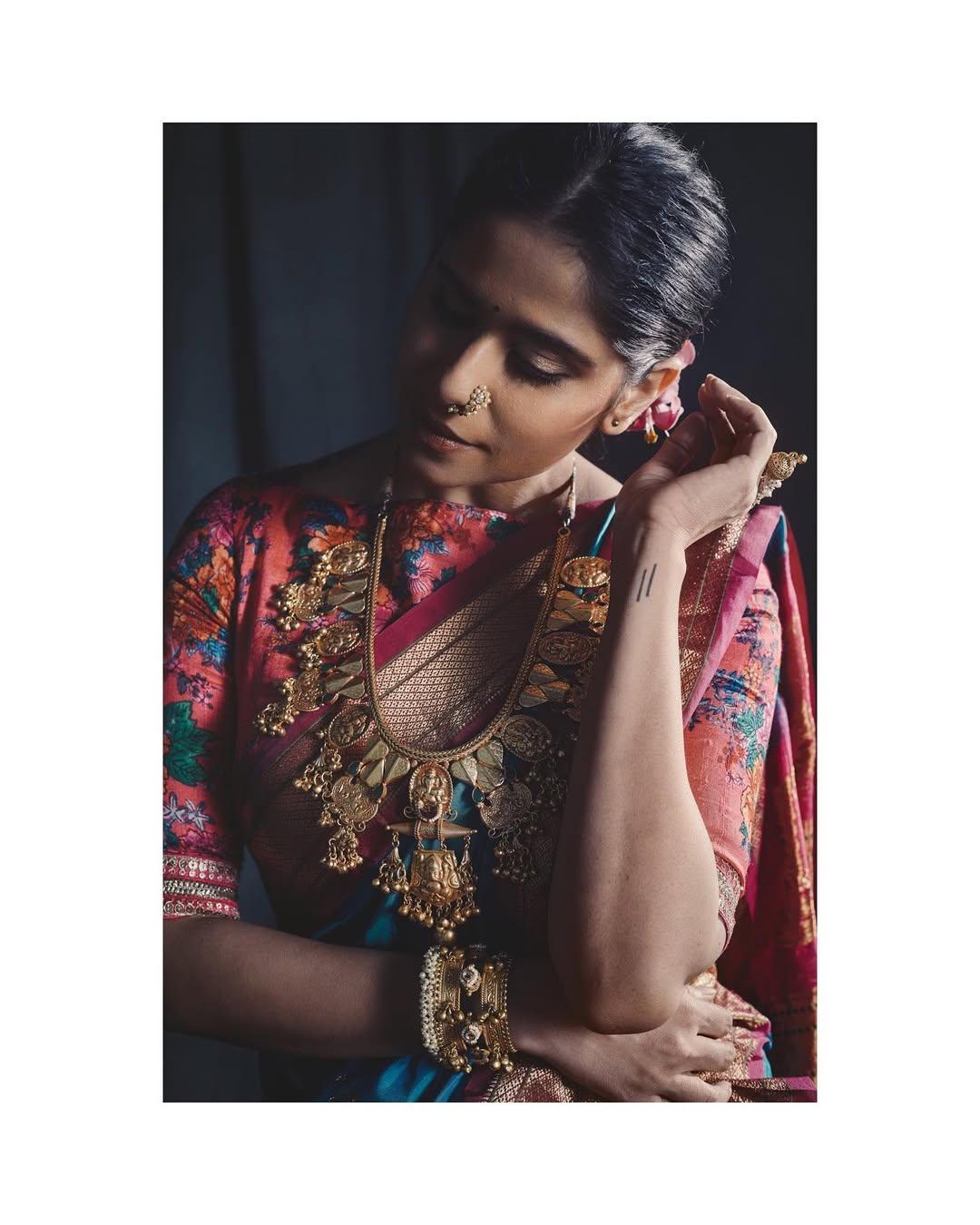 Sai further accessorized her look with multiple necklaces, some beautiful kadhas, and minimal makeup. She elevated her bun with flowers and finished the look with an intricate nath