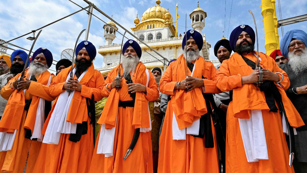 Sikh holy men known as 'Panj Pyare' hold swords during a procession to mark Hola Mohalla festival, celebrated a day after Holi, the spring festival of colours, at the Golden Temple in Amritsar on Saturday