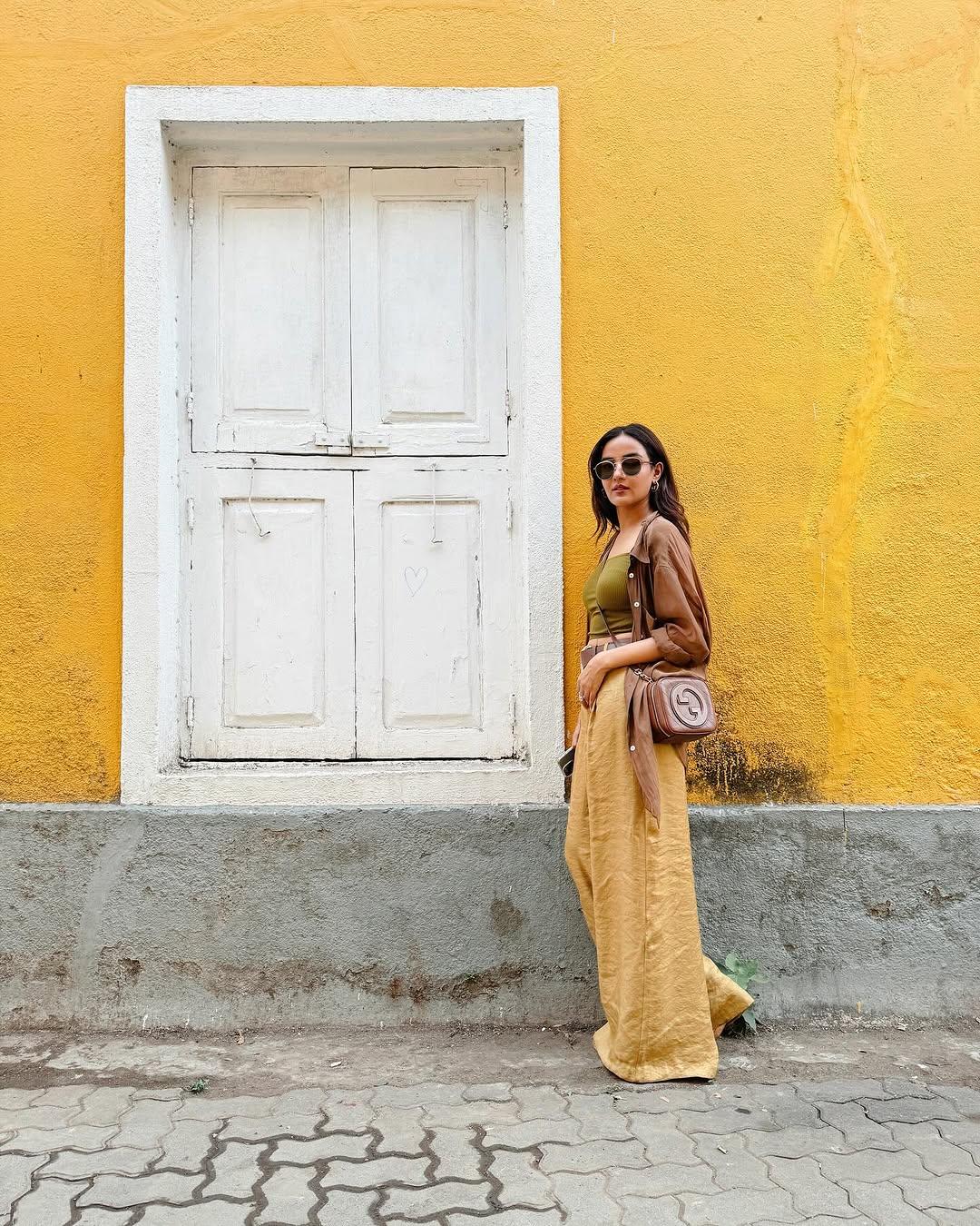 In this look, the actress paired stunning beige-coloured wide-legged pants with a green-coloured tank top, which established a perfect contrast. She further elevated her appearance with a brown shirt.