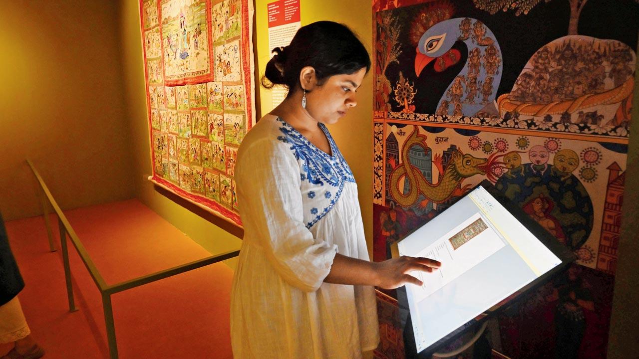 The writer tries out an interactive kiosk at the gallery which  lets viewers attempt quizzes and play folk art-themed jigsaw puzzles based on the artworks on display