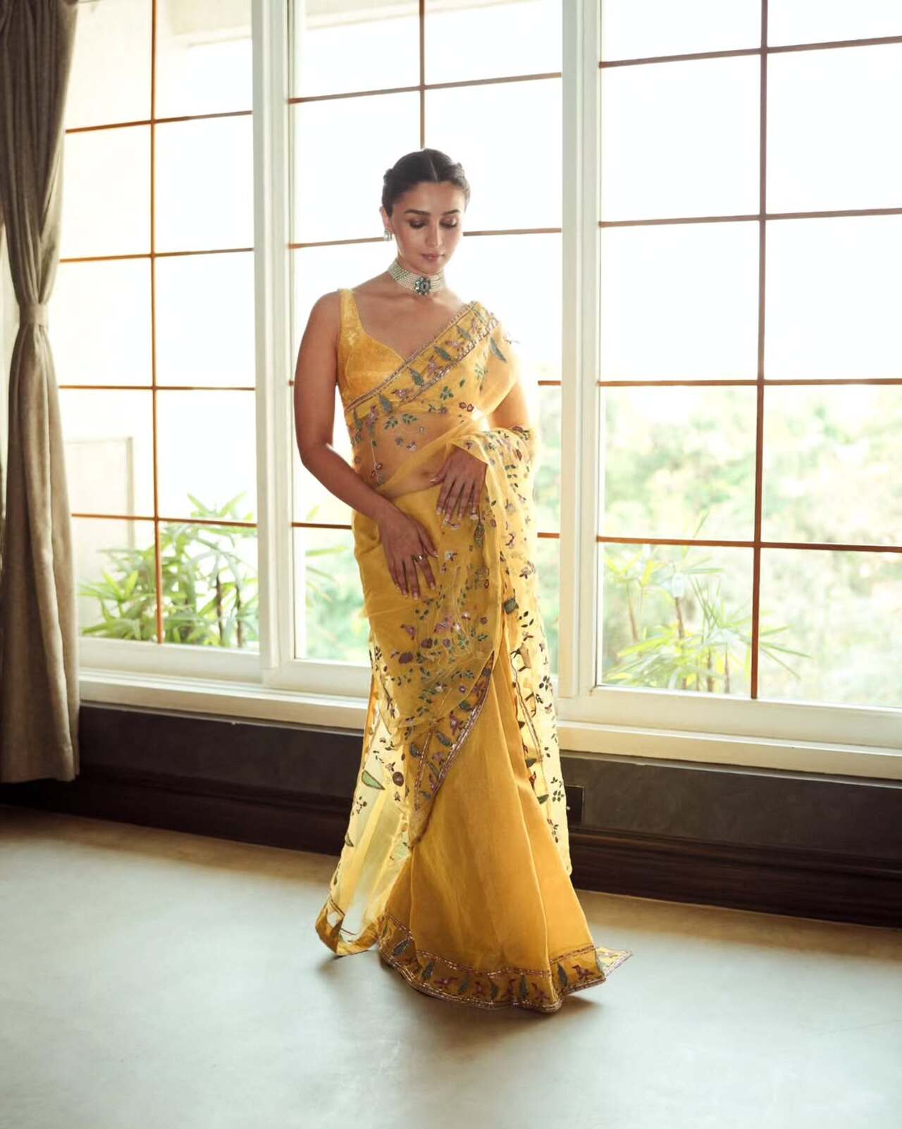 A delicate tapestry of nature, the sari featured an aviary pattern with house sparrows, cranes, fawns, and blooming flora, all brought to life through intricate hand applique and aari embroidery. A vision of understated elegance, Alia effortlessly merged heritage craftsmanship with her signature grace.
