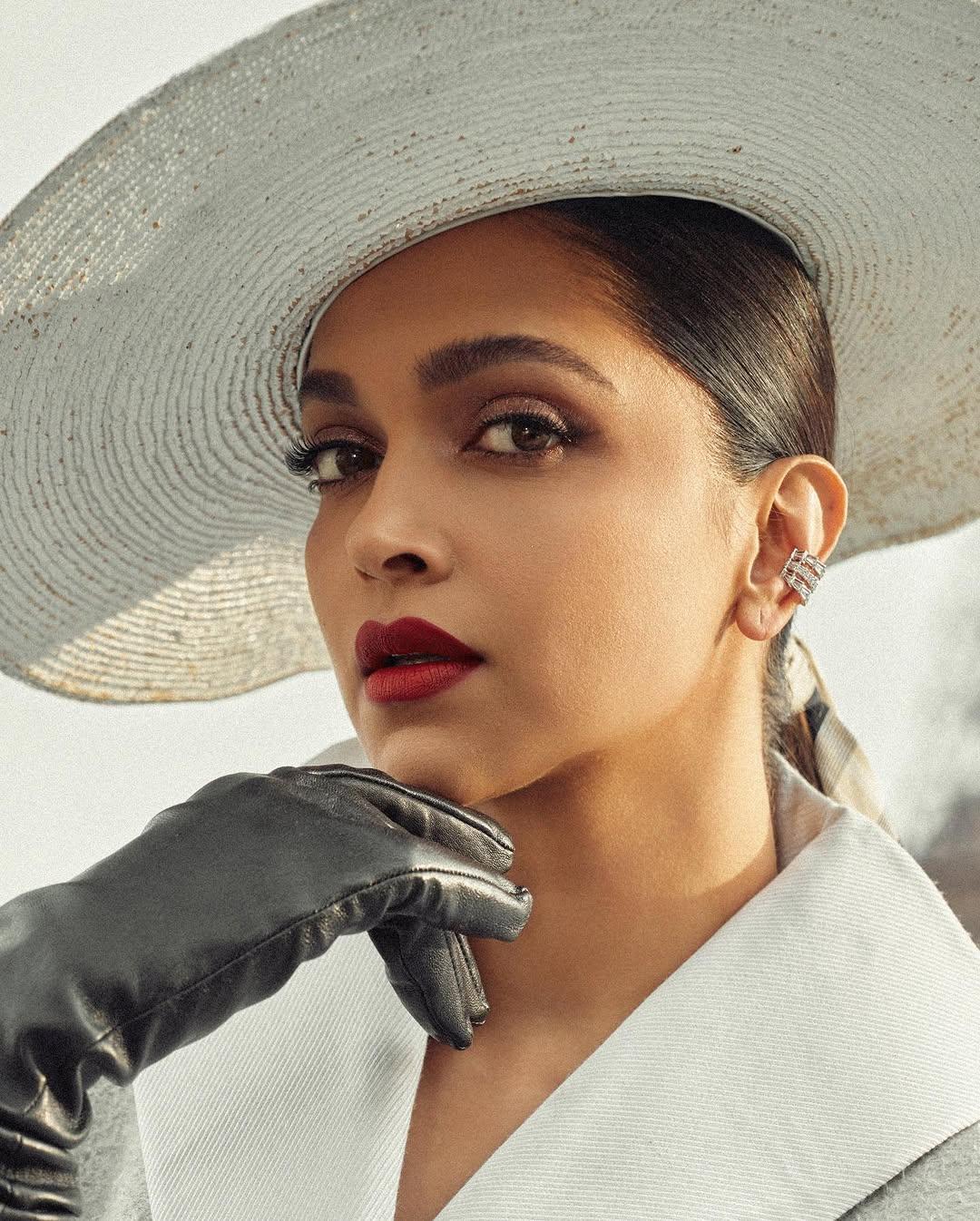 She elevated the look with an oversized white hat, black leather gloves, sheer stockings, pointed pumps, flawless makeup, and a sleek ribbon-tied ponytail.
 
