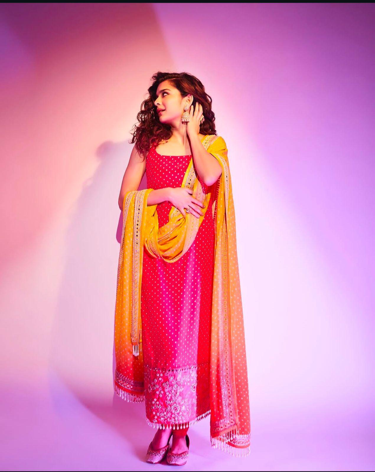 Mithila Palkar looks radiant in a bright pink kurta set, adding contrast with an ombre dupatta. She completes her look with statement jhumkas and mojaris for a perfect festive touch
