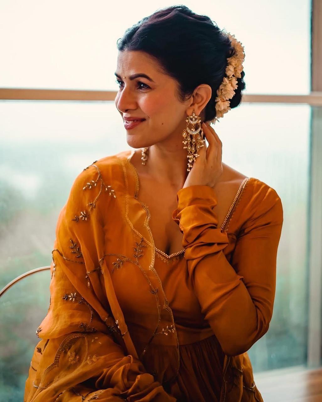 Nimrat Kaur oozes elegance in a mustard yellow Anarkali set, demonstrating how to make an effortless statement. She adorns her hair with gajras and opts for statement jewelry to complete the look