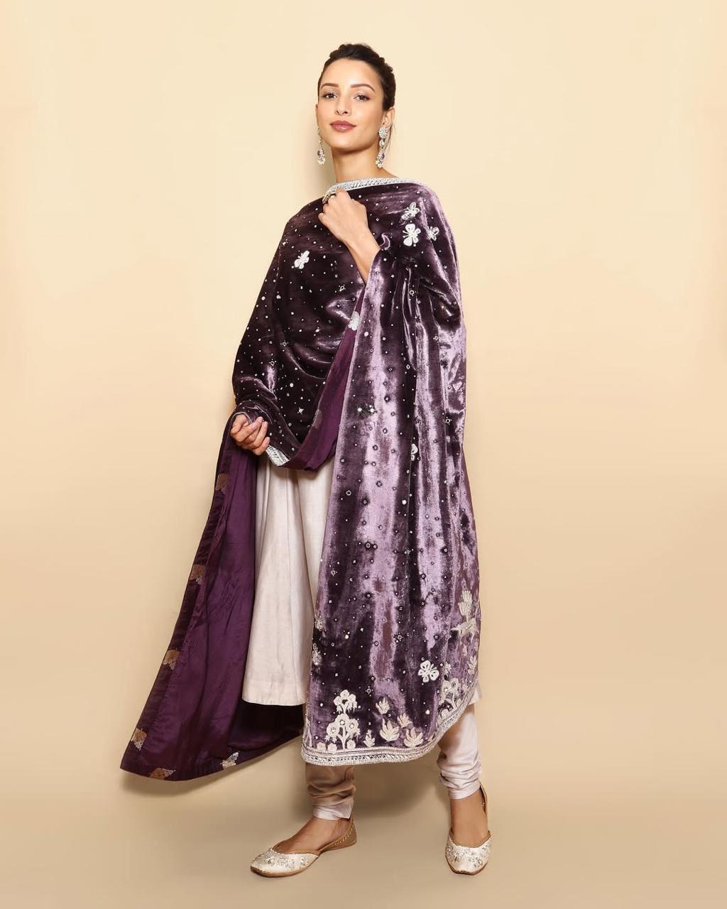 Triptii Dimri stuns in a light purple Anarkali suit, adding a bold contrast with a deep purple velvet dupatta. She accessorizes with heavy drop earrings, allowing her outfit to make a statement