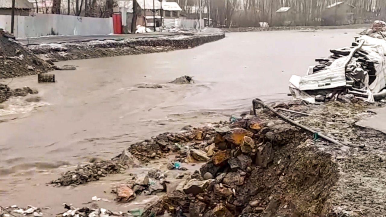 Water flows on Frisal-Khudwani road, resulting in the collapse of its diversion after heavy rainfall, in Kulgam