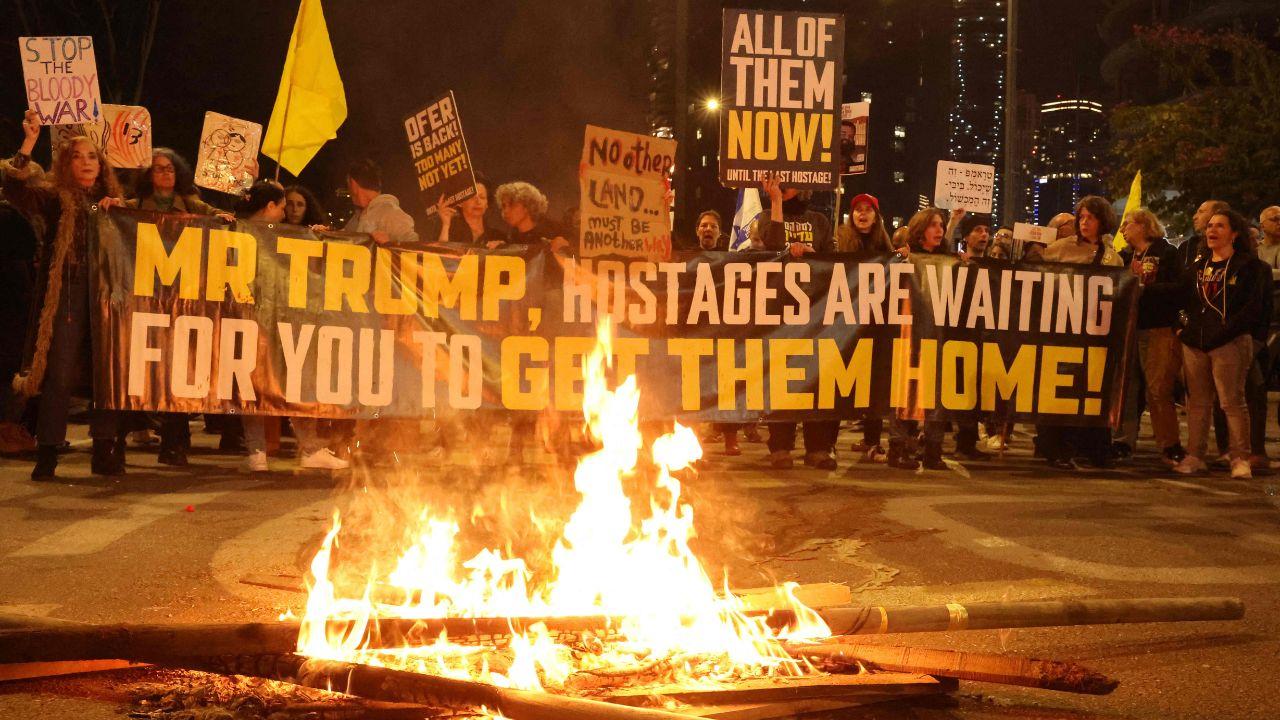 Protesters hold banners that read, ' Mr Trump, Hostages are waiting for you to get them home, ' as they protest for the release of Israelis  