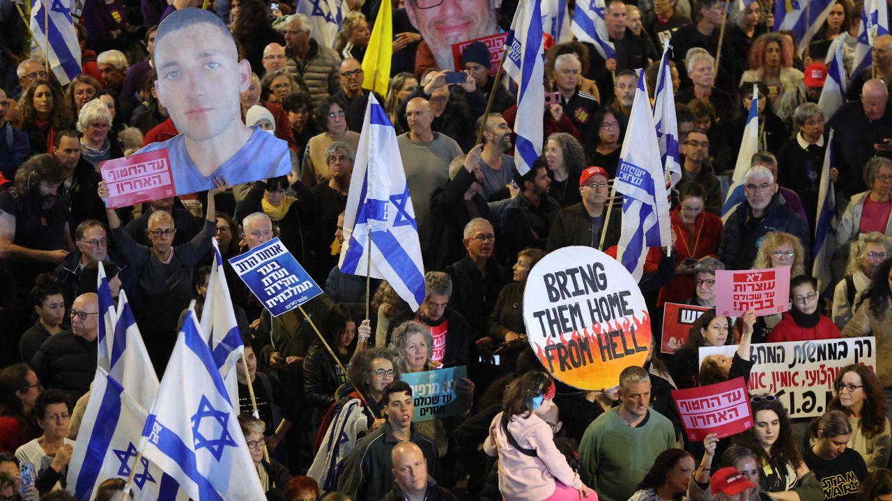 Protesters lift placards during a rally in front of the Israeli defence ministry in Tel Aviv on March 8, 2025