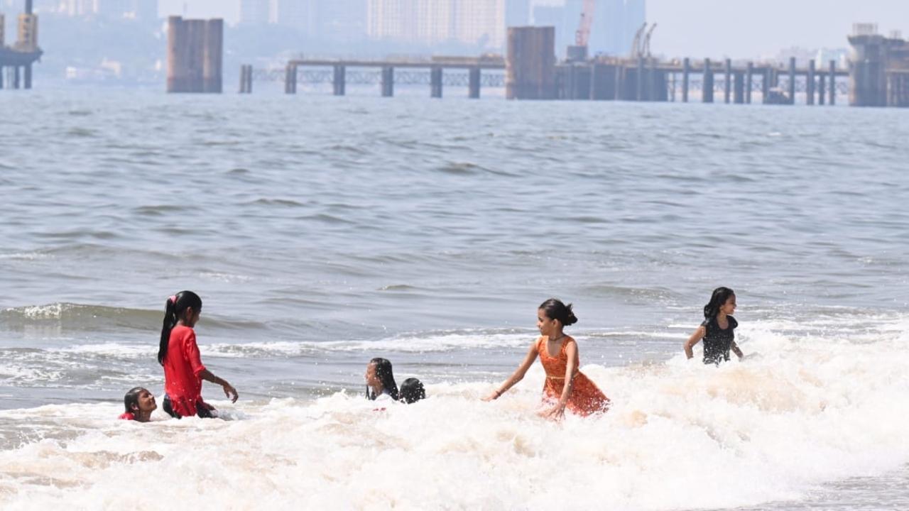 Visitors take dip at Juhu beach as Mumbai continues to witness hot weather
