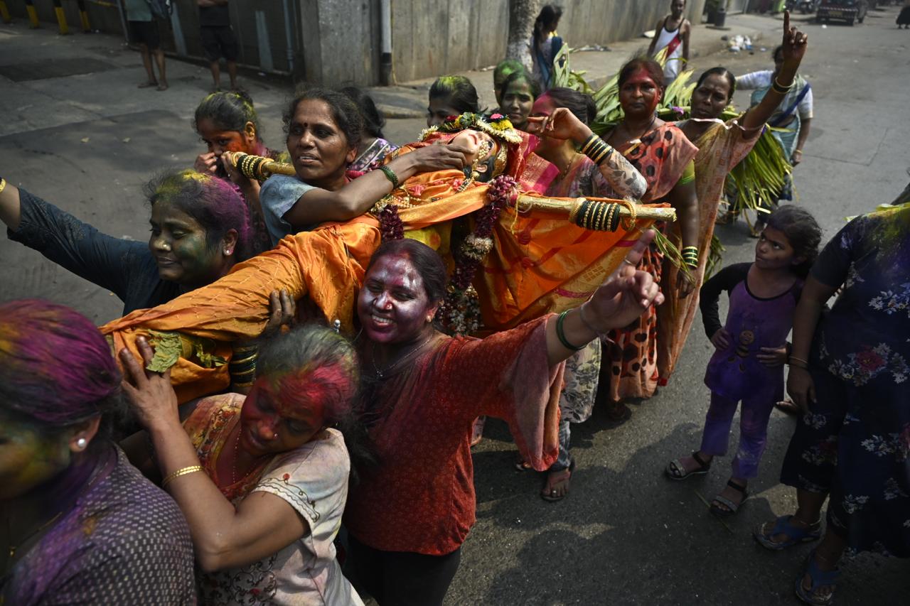 The air was thick with the scent of gulal and the sounds of joyous celebration.