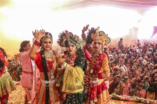 Artists dressed as Lord Krishna and Goddess Radha bring the spirit of Holi alive during the 'Faag Mahotsav' at Govind Dev Ji Temple, Jaipur.