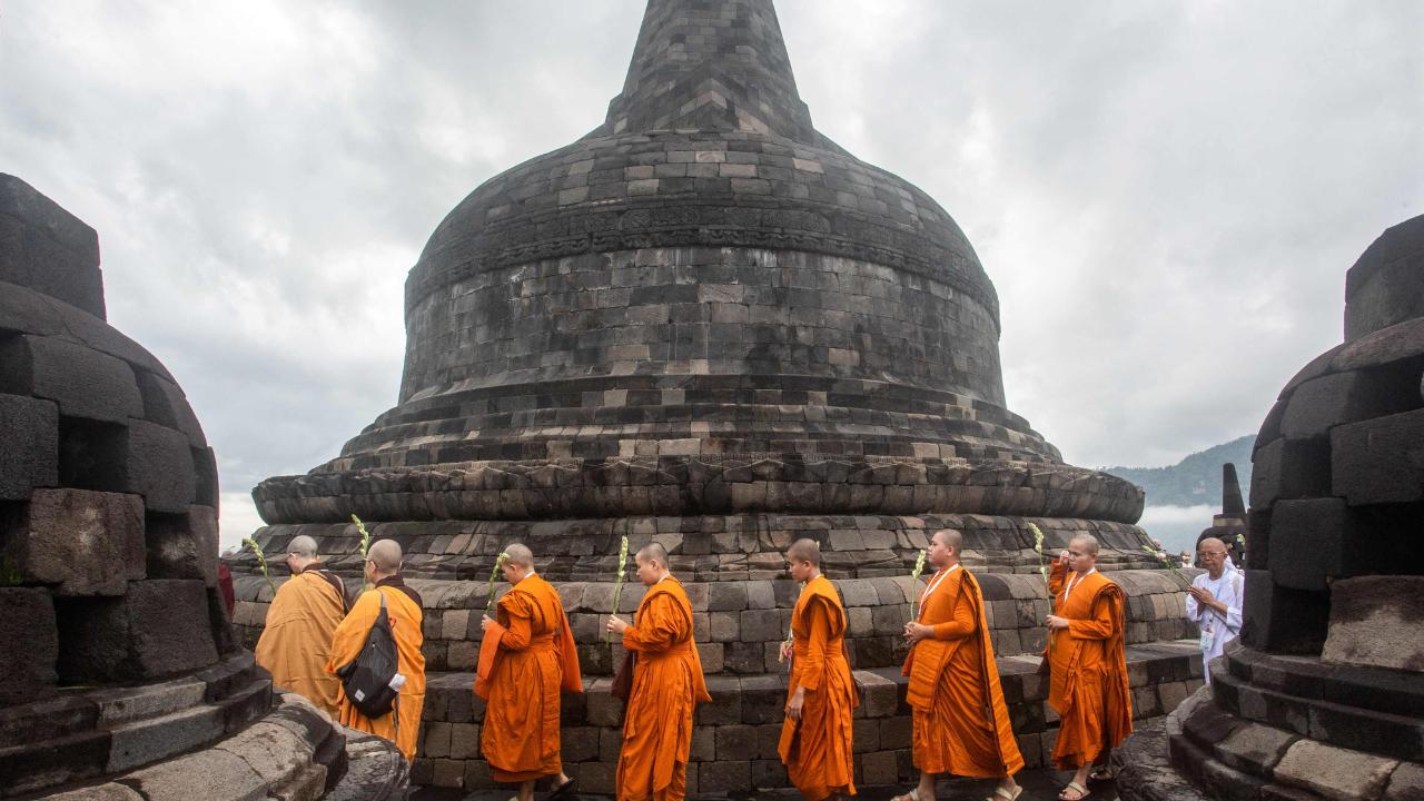 Buddhist monks pray among stupas and offer prayers to Buddha for world peace on the eve of 50th International Women’s Day