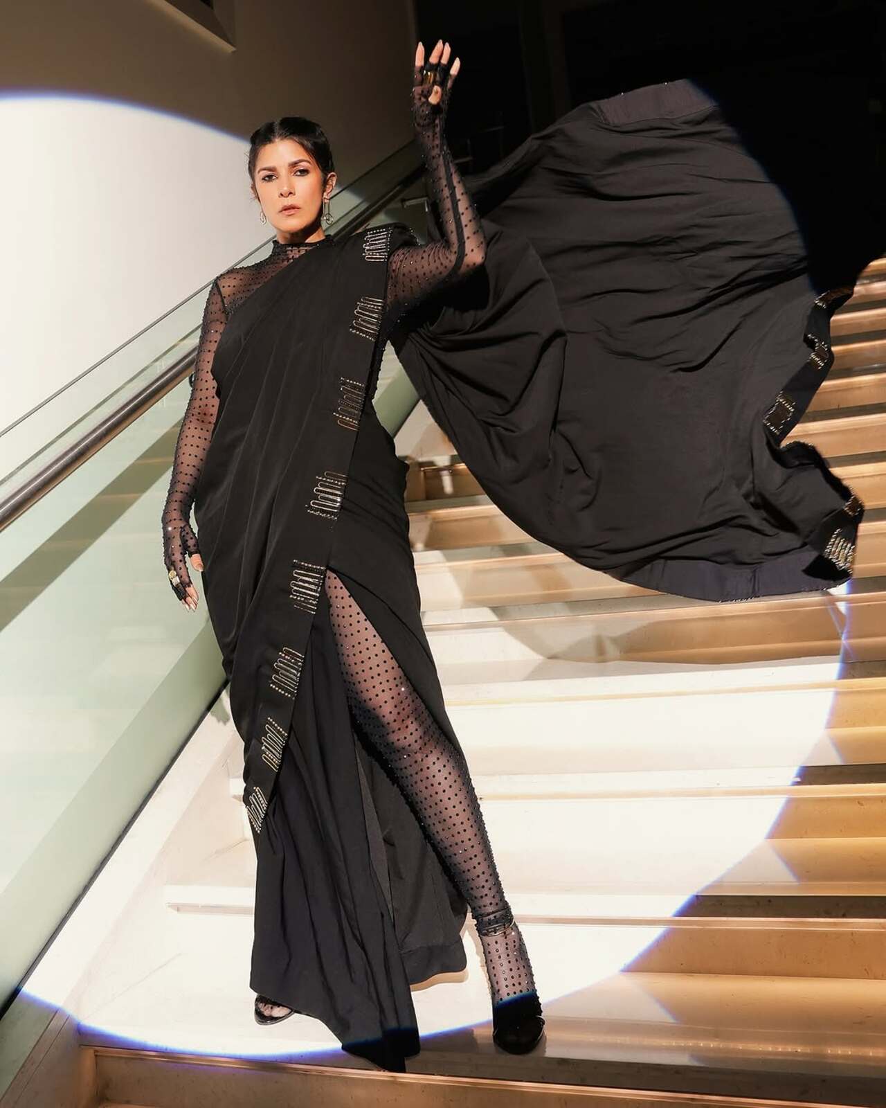 Nimrat gives a stellar western twist to the desi saree for an awards night. She paired the saree with see-through stocking and we are totally loving his bold take on a black saree.