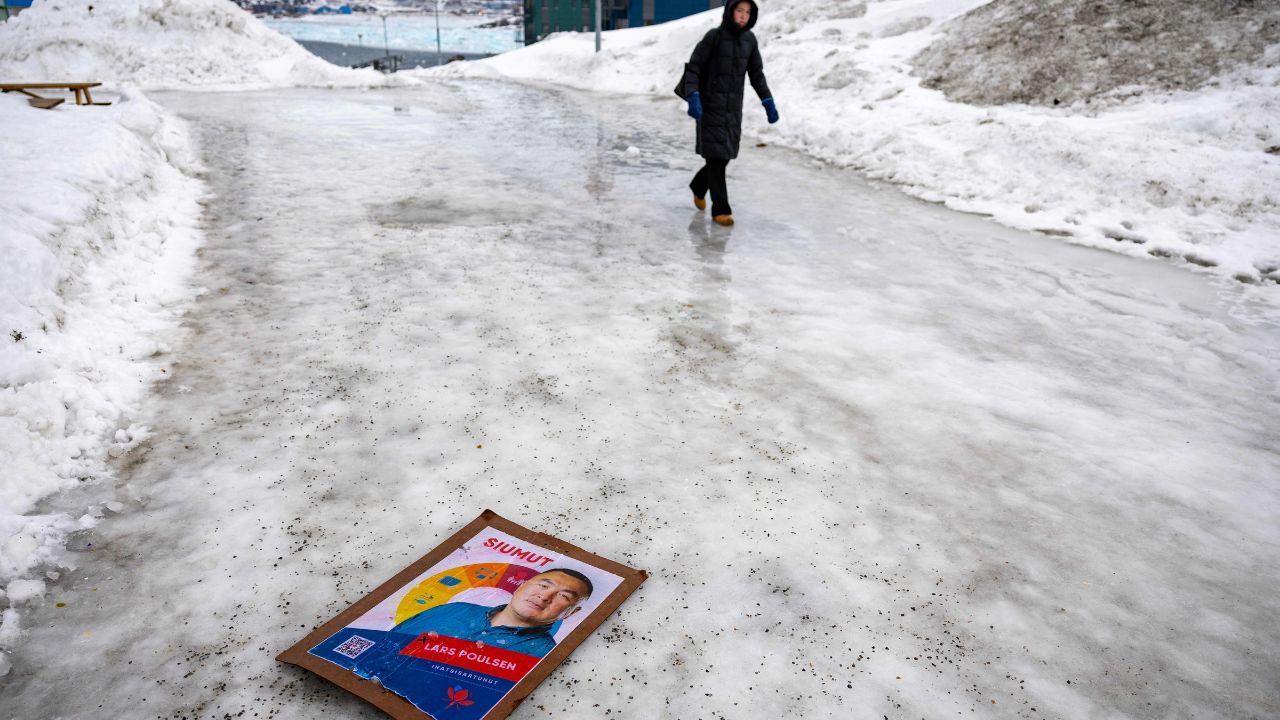 A poster for the Greenlandic political party Siumut lays on the waterlogged ice in Nuuk as major ice sheet in green has melted 