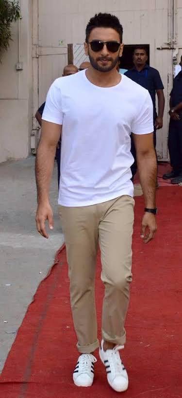 Ranveer donned a crisp white T-shirt paired with cream-colored pants, creating a clean and effortless look. The white T-shirt serves as the perfect casual attire, ideal for embracing the vibrant splashes of Holi colors in style.