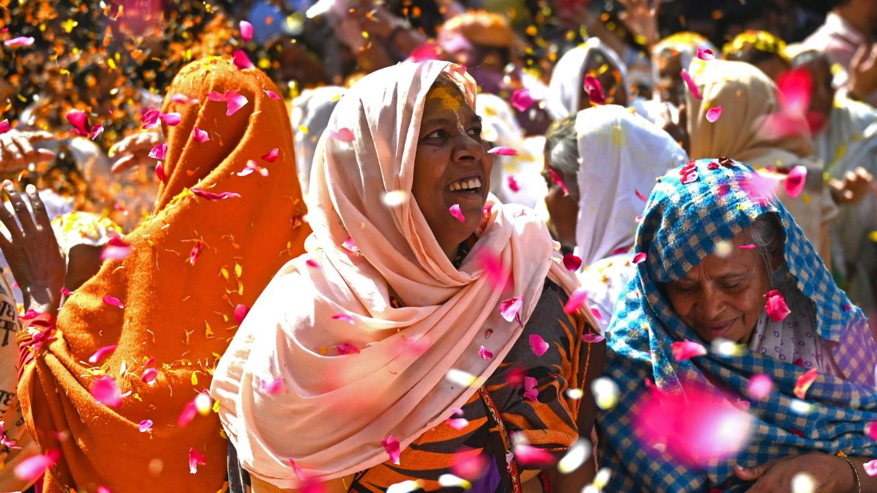 Devotees dance in the rain of flower petals with great joy