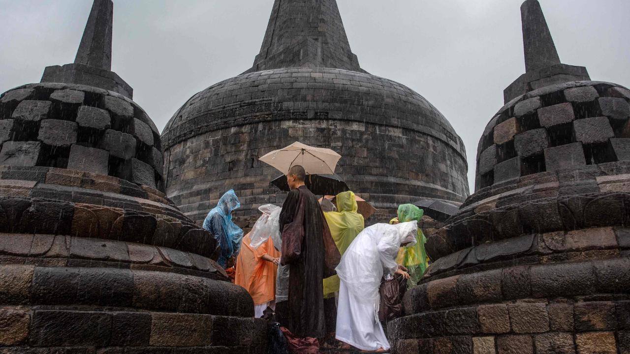 Female Buddhist monks put on rain jackets after their prayer at Indonesia's Borobudur Temple