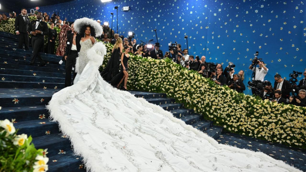 Diana Ross
Music star Diana Ross made a glorious comeback at Met Gala after over 20 years, stealing the show in a sparkling silver-white ensemble. The showstopper of the look was the white-feathered cape with a long train. At the event, Ross revealed that the massive garment featured the names of her children and grandchildren. She completed her look with a white feathered hat