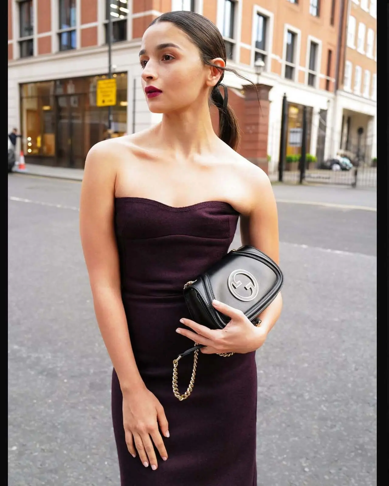 Slaying in her strapless black dress, she styled her hair in a bun, carried a black Gucci bag, wore matching heels, and opted for a rich maroon lipstick to complete the look
