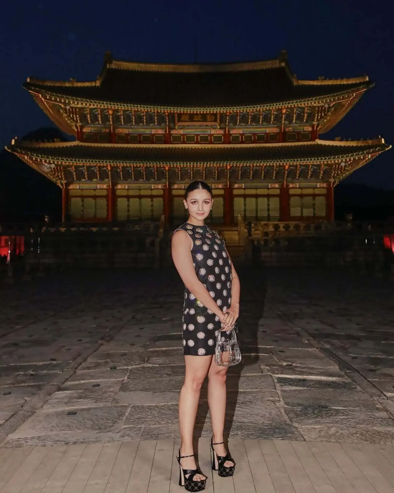 She wore a black cutout dress with platform heels and posed alongside global icons like Dakota Johnson and Korean singer IU