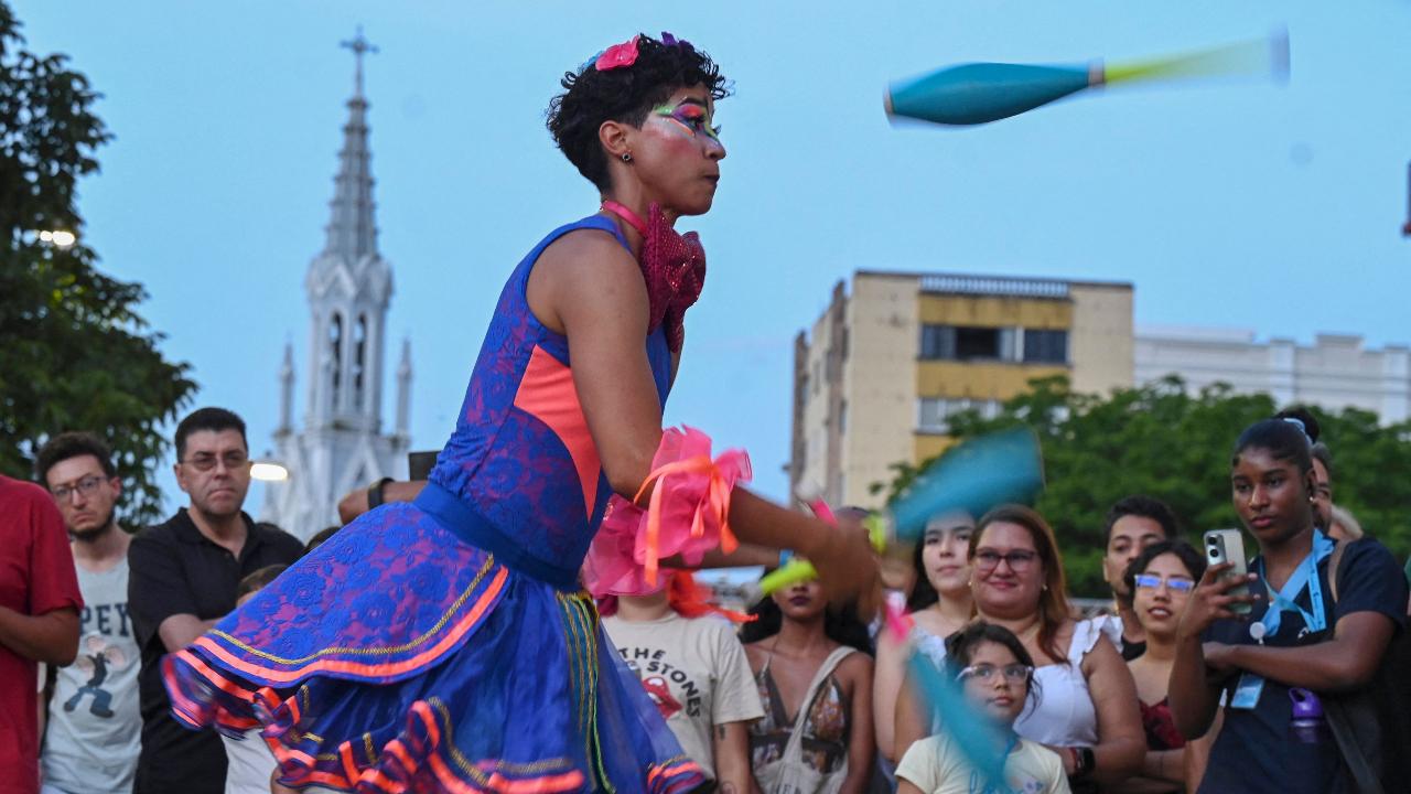 Dressed in colourful outfits, artists took to the streets as people watched in awe. In photos, an artist performs during the inauguration of Cali’s International Theatre Festival
