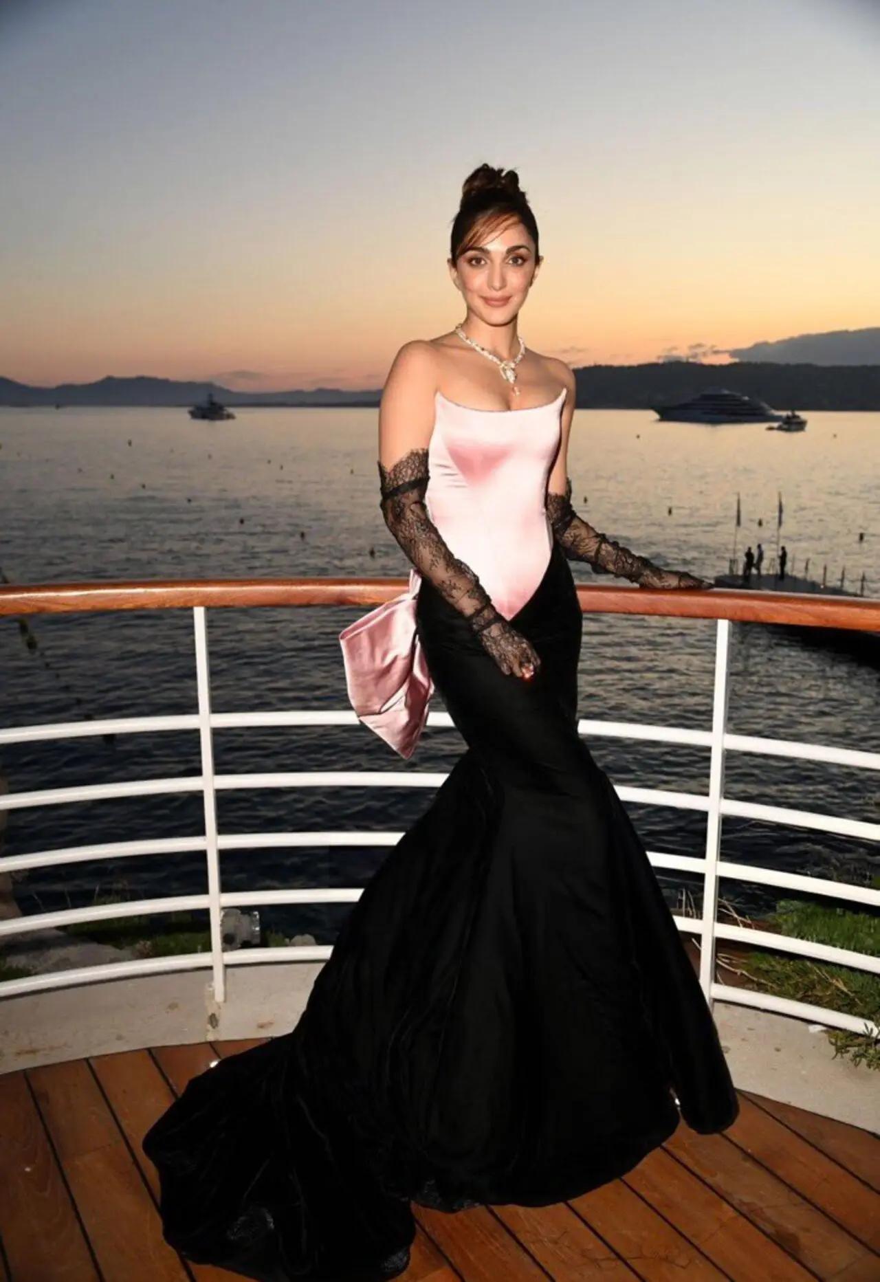 Actor Kiara Advani attended the Red Sea Film Foundation's Women in Cinema Gala dinner at Cannes 2024, wearing a silk off-shoulder pink and black gown by Prabal Gurung. Styled with a dramatic pink bow, high bun, lace gloves, and a statement necklace, Kiara looked like an absolute doll