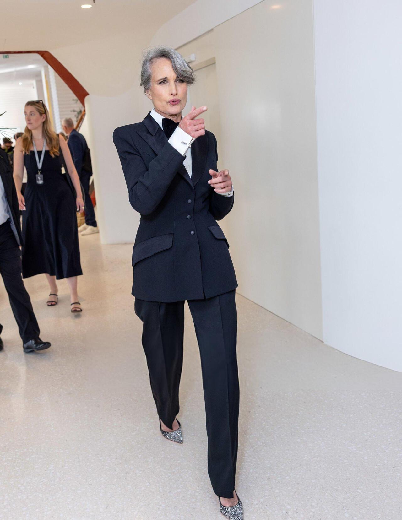 Legendary actress Andie MacDowell turned heads on Day 2 of Cannes 2025 in a black tuxedo with her iconic silver hair pulled back. She stood out among other top actresses who appeared on the red carpet in full-length gowns